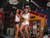 Girls dancing around a pole at a beer bar
